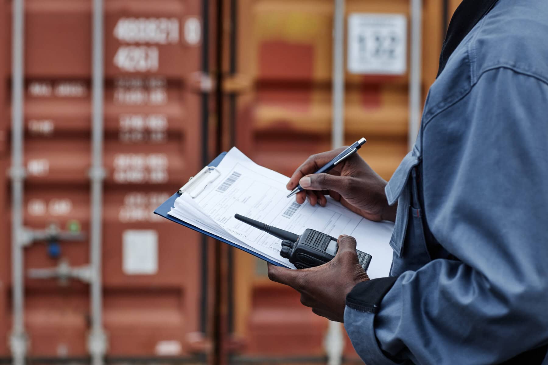 Close up of male worker writing on clipboard